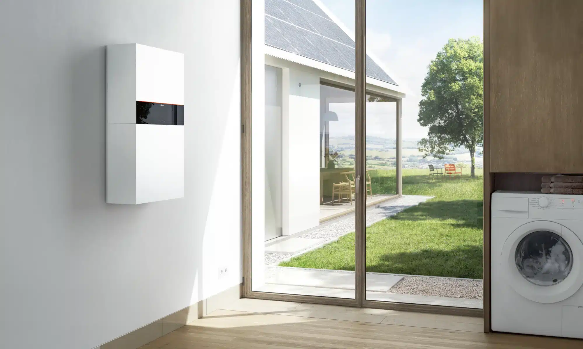 Viessmann Stromspeicher Vitocharge VX3 an der Wand, draußen ein Haus mit Photovoltaikanlage