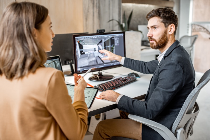 Berater zeigt einer Kundin eine 3D-Planung am Bildschirm